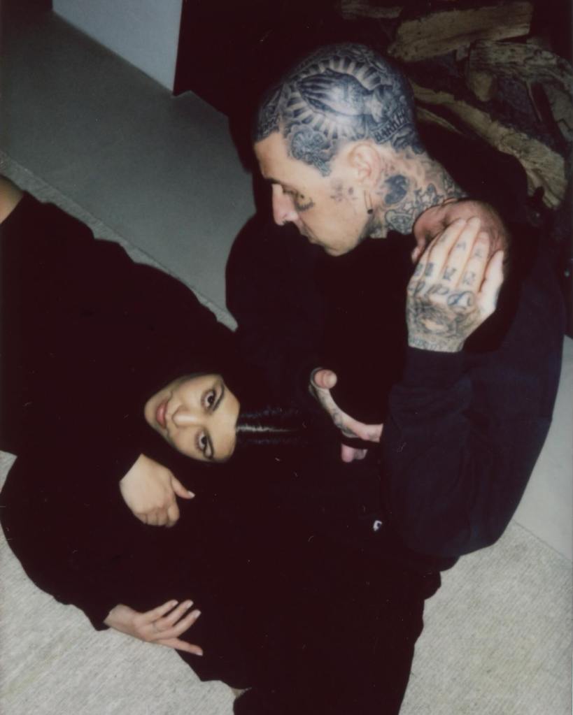 Kourtney Kardashian holding her infant son, Rocky, as Travis Barker gently cradles the baby's head.