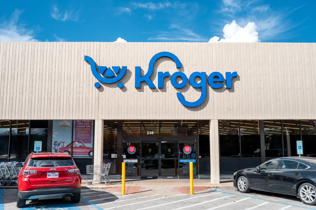 Exterior of a Kroger grocery store, showing the entrance and parking lot.