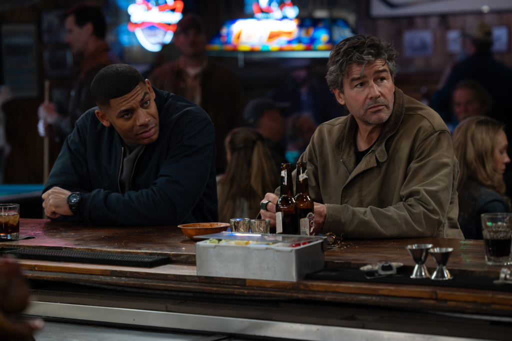 Kyle Chandler and Aaron Pierre sitting at a bar in the HBO show