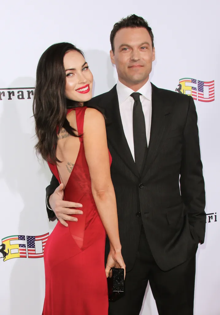 Megan Fox in a red gown and Brian Austin Green in a black suit pose for a photo.