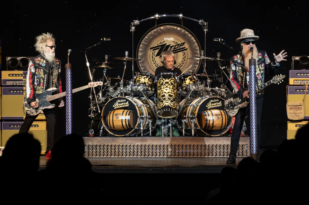 Three members of ZZ Top perform on stage.