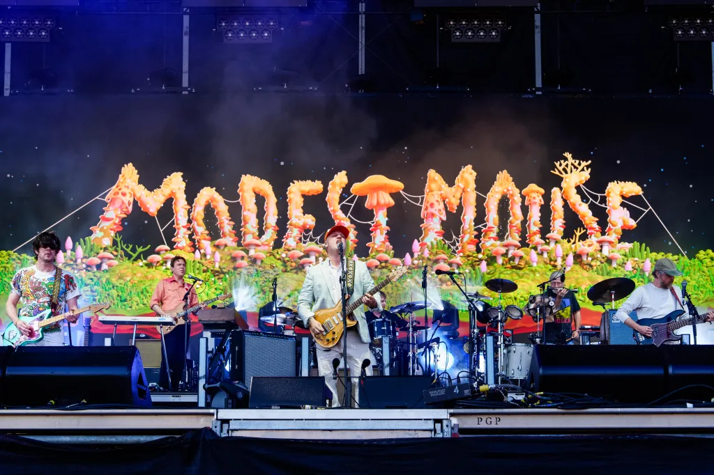 Modest Mouse performing at Austin City Limits Music Festival with a large mushroom-themed stage backdrop.