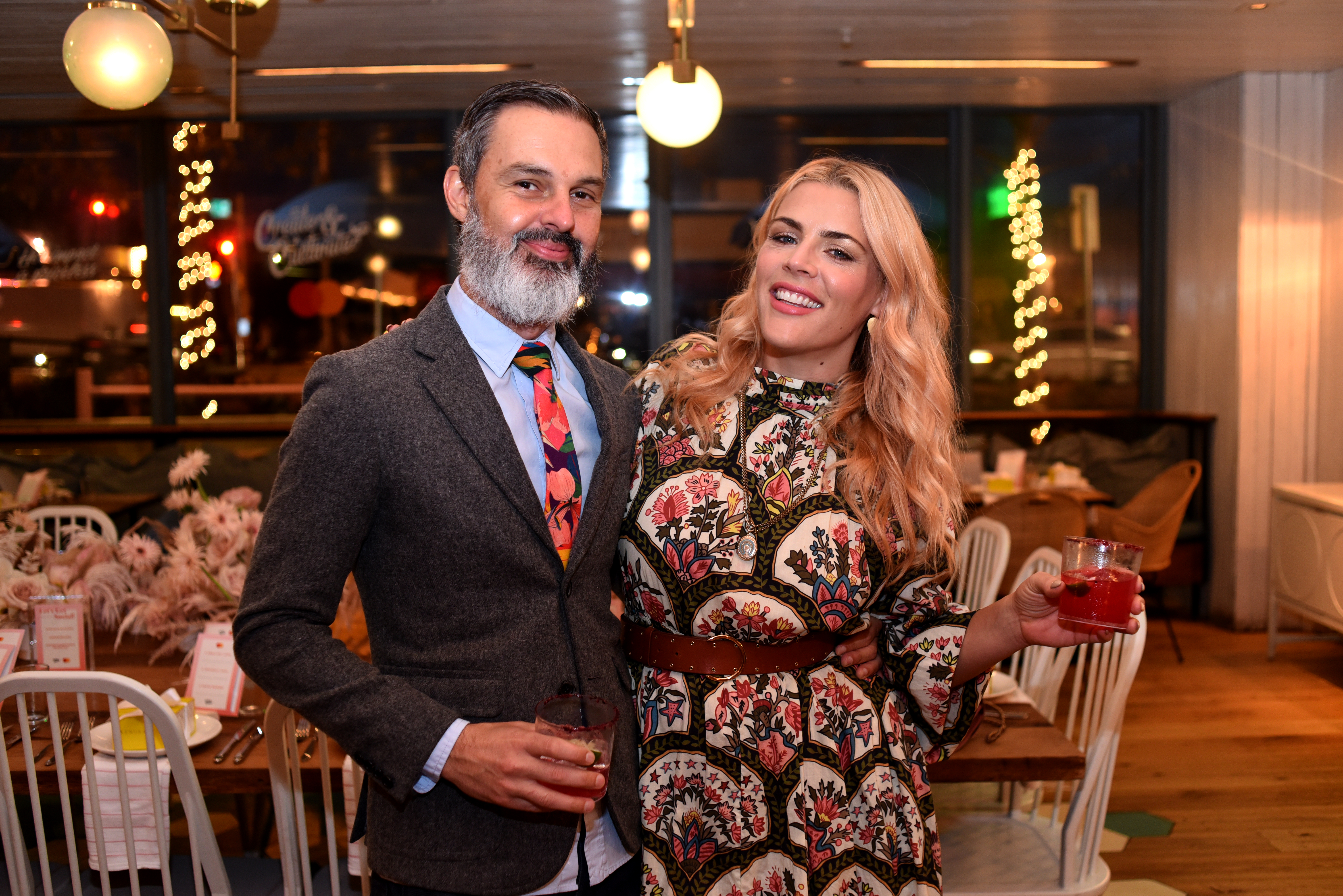 Marc Silverstein and Busy Philipps smiling at an event.