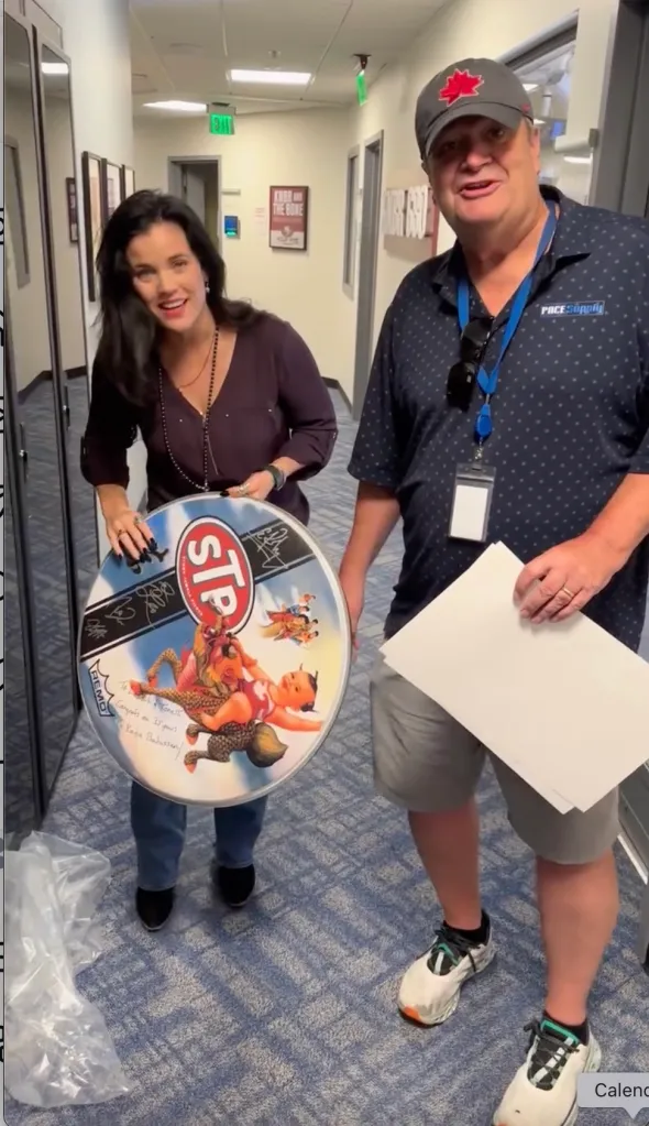 Lamont Hollywood, right, pictured with a woman holding a signed STP drumhead.