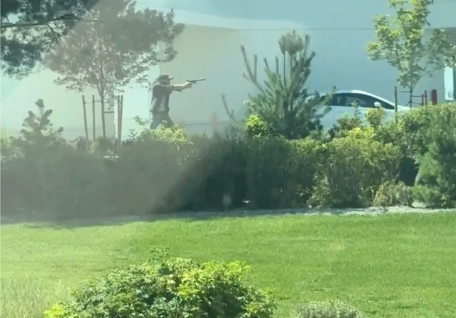 A man aiming a handgun in a public setting.