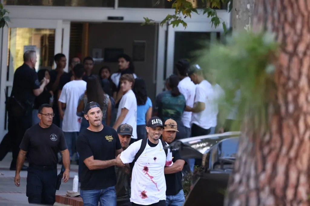 People playing victims with fake blood on their shirts during an LAPD SWAT drill.