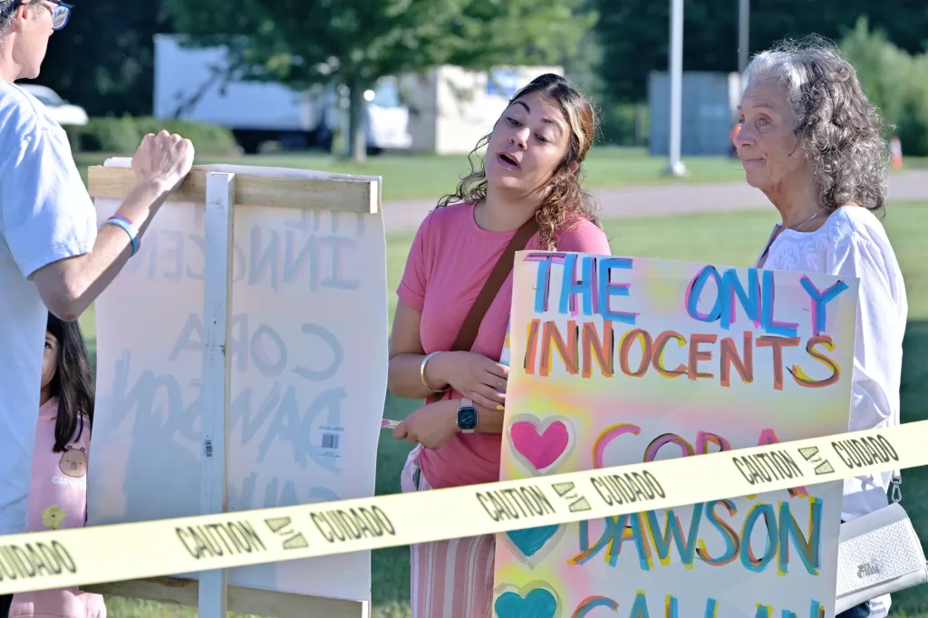 A Lindsay Clancy supporter reads signs implying the guilt of Lindsay and Patrick Clancy.