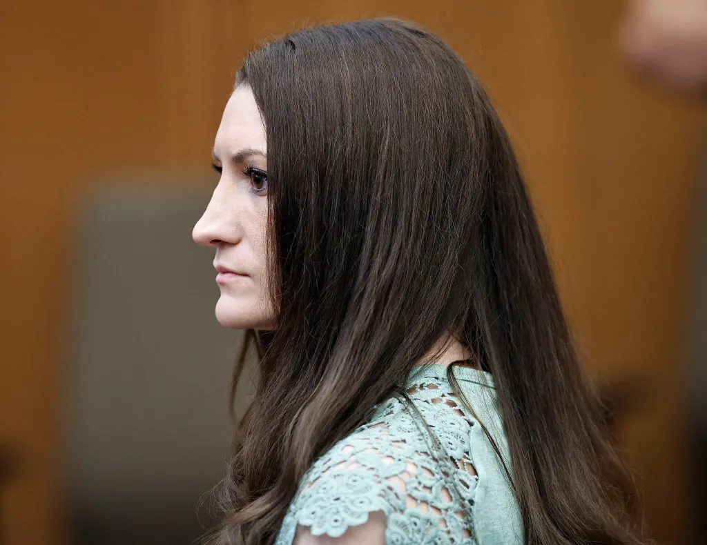 Lindsay Clancy looking right with brown hair and wearing a teal lace top at her murder trial.