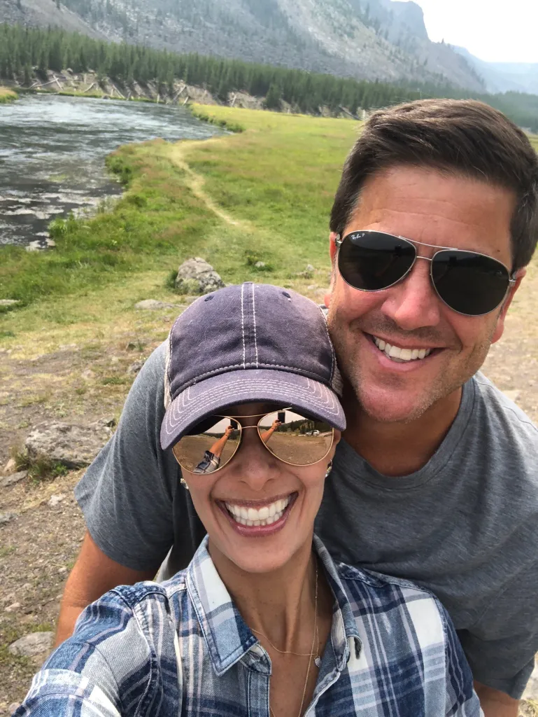Liz Cho and Josh Elliott posing for a selfie outdoors.