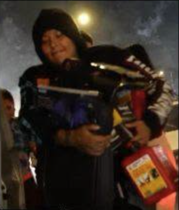 Suspect in a dark hoodie carrying stolen car parts and a red gasoline can.