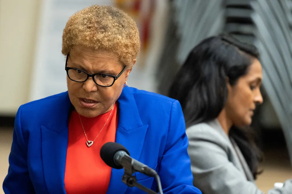 Karen Bass speaking at a debate with Nithya Raman in the background.
