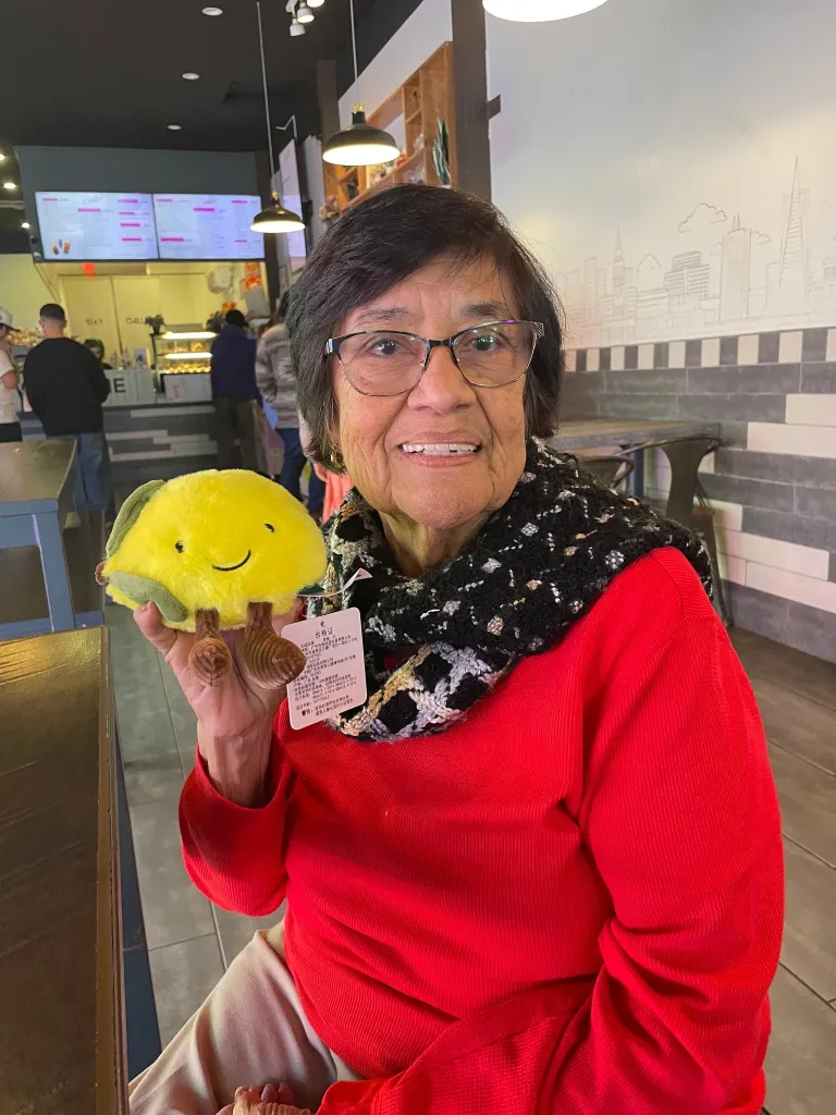 Cristina Vargas holding a cheerful yellow taco plush toy.