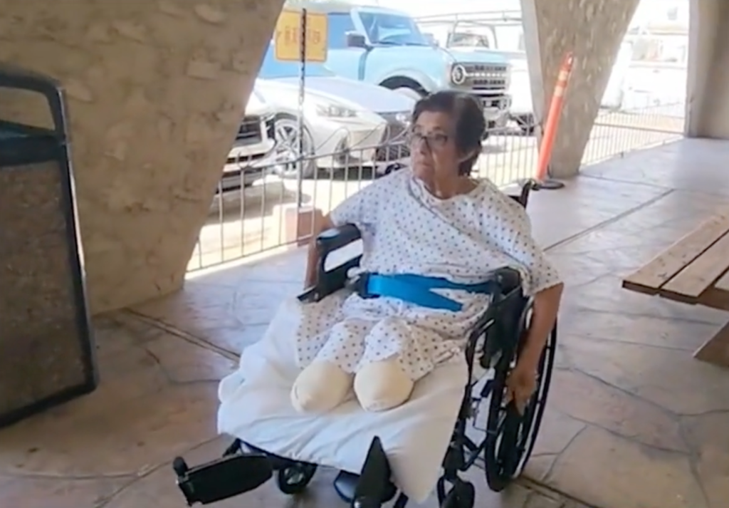 Cristina Vargas, who lost both legs in a car crash, sits in a wheelchair wearing a hospital gown and a blue safety belt.