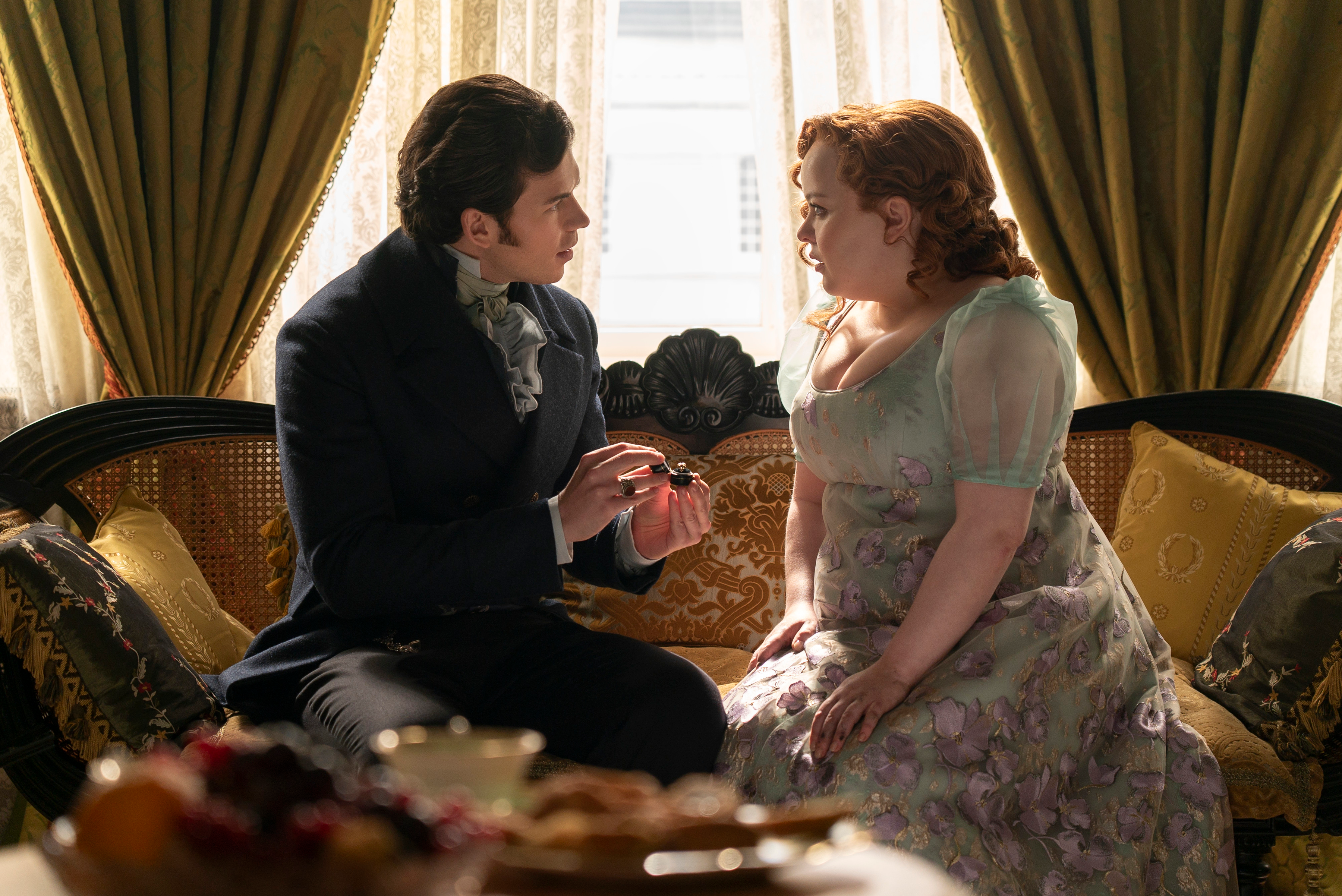 Colin Bridgerton proposing to Penelope Featherington with an open ring box.