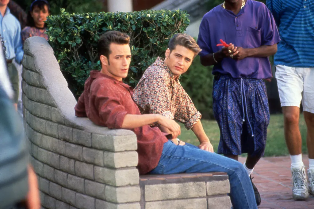 Luke Perry and Jason Priestley looking over their shoulders on the set of Beverly Hills 90210.