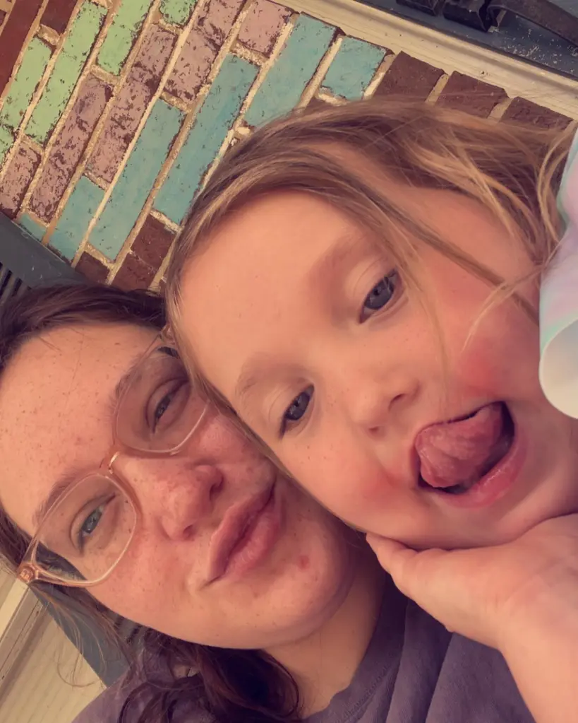 A woman with glasses and a child making a face.