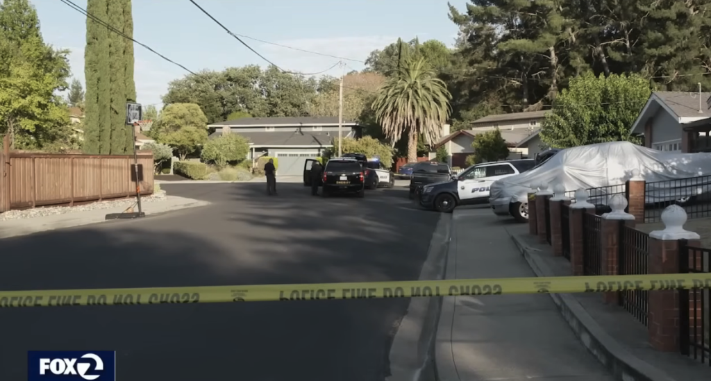 Police and sheriff's vehicles on a residential street cordoned off with yellow tape.
