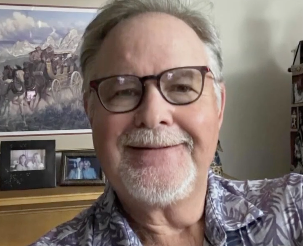 Todd Stewart, a man with a white goatee and glasses, smiling into the camera.