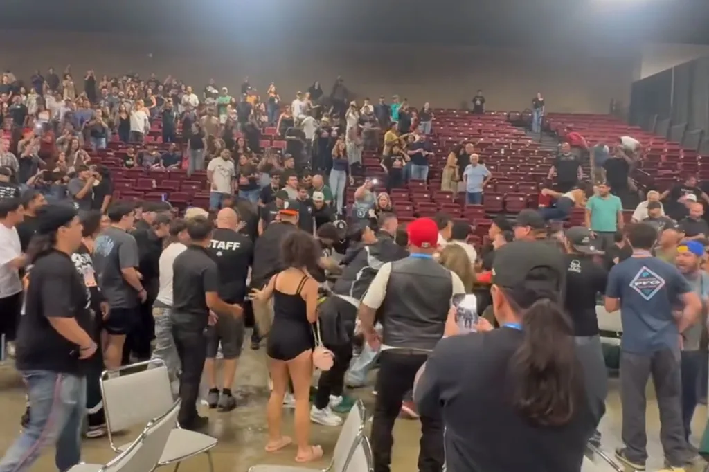 A massive brawl breaks out at the Visalia Convention Center, with many people fighting and others watching from the stands.