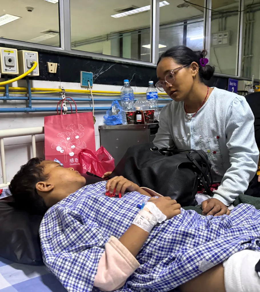 Matti Maya Tamang looks at her son Zoyal Ghale in a hospital after they were separated by floods in Nepal.