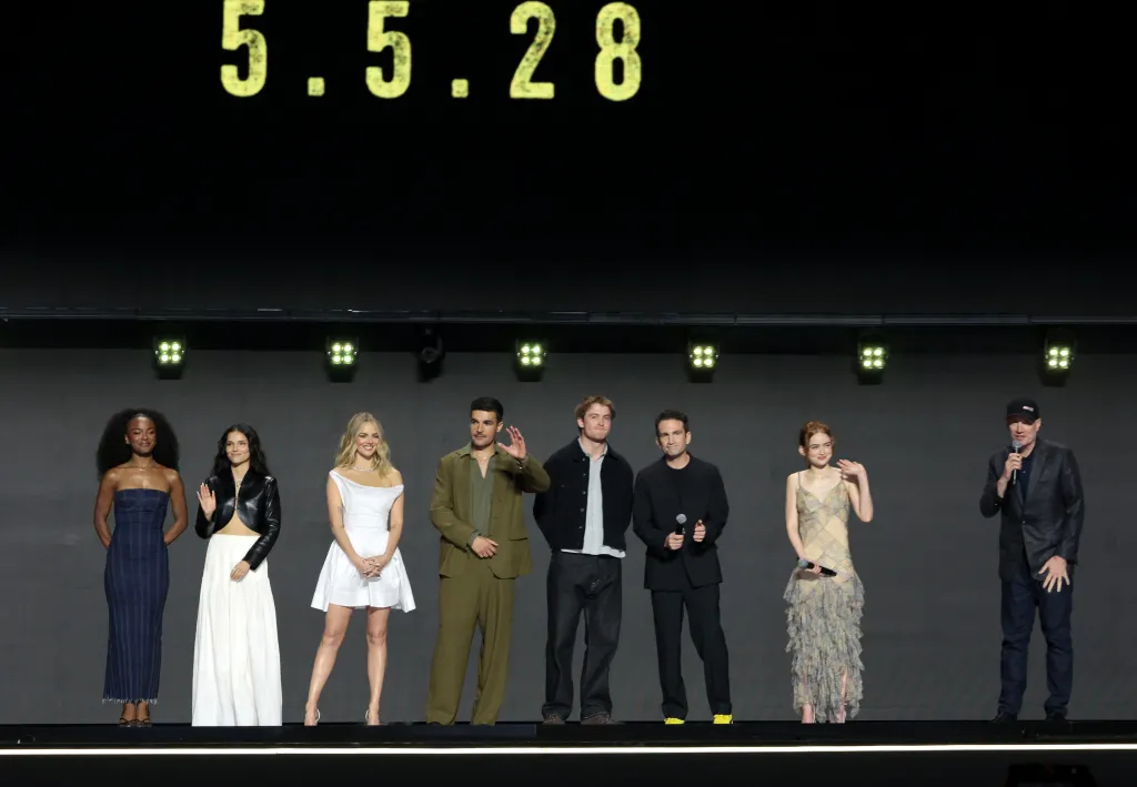 Maya Boyd, Inde Navarrette, Samara Weaving, Christopher Abbott, Kit Connor, Jake Schreier, Sadie Sink, and Kevin Feige standing on stage at D23: The Ultimate Disney Fan Event.