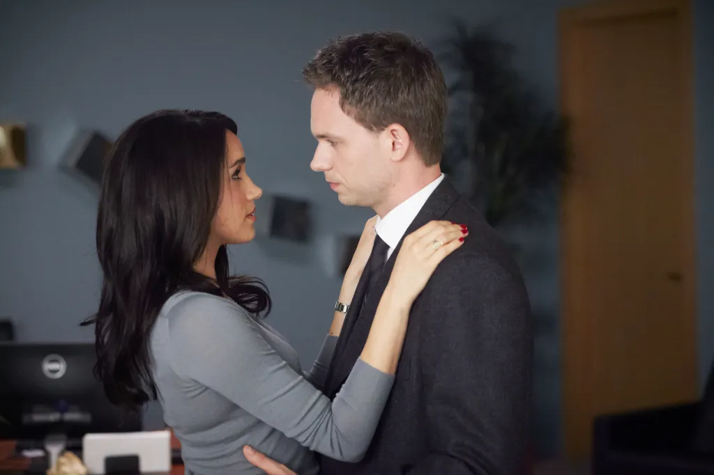 Meghan Markle and Patrick J. Adams looking at each other, with Markle's arms around Adams' neck.