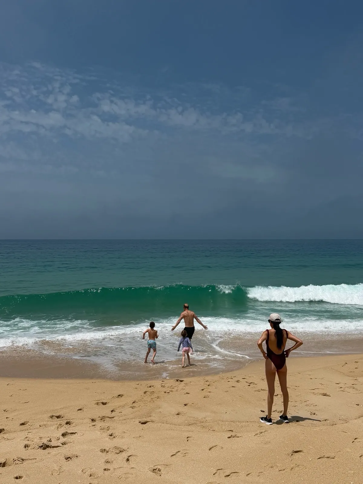 Family playing in the waves at the beach.