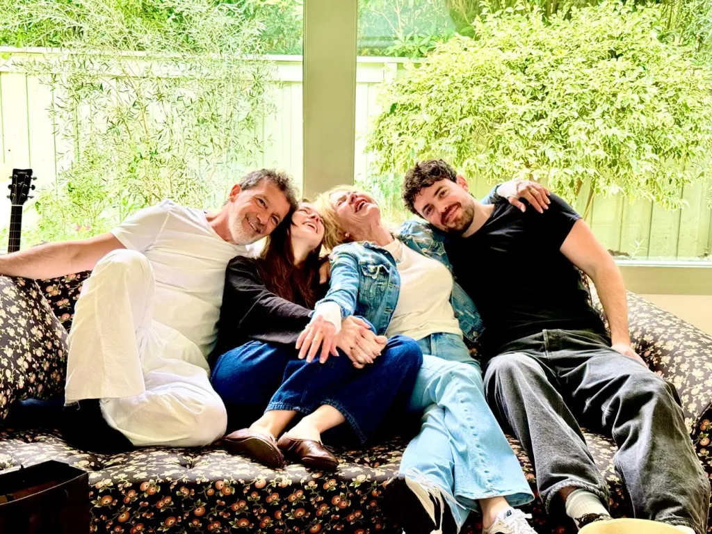 Antonio Banderas, Melanie Griffith, and two young adults laughing on a couch.