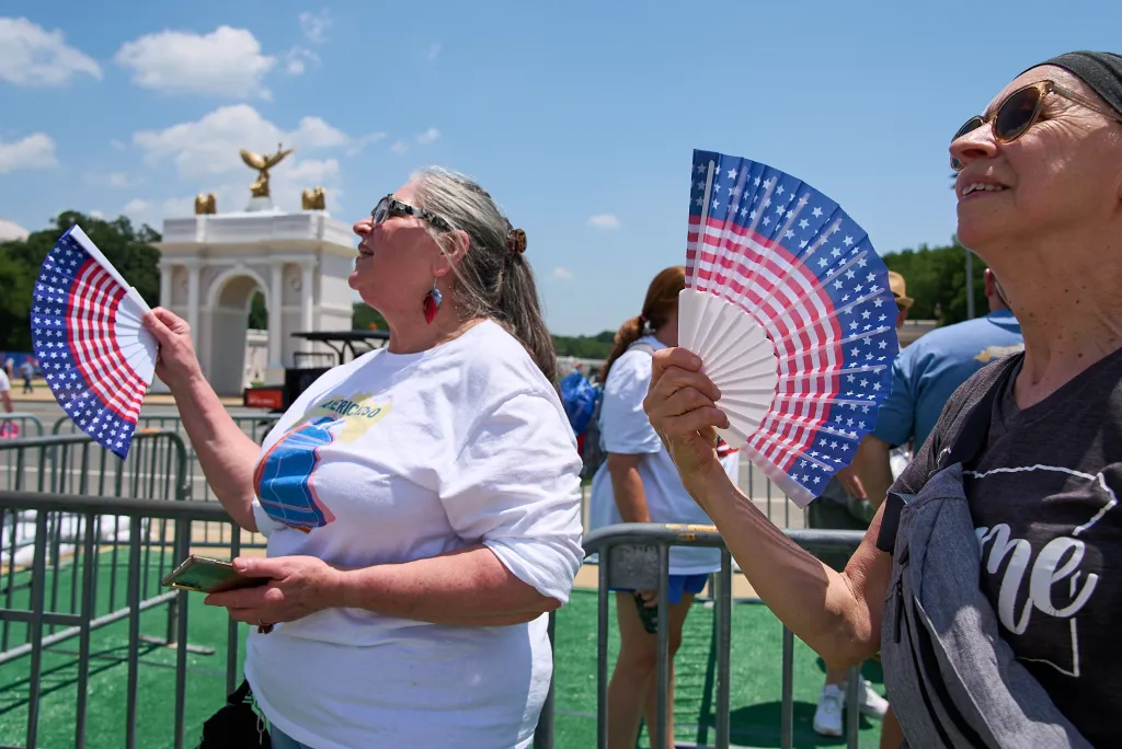 Mickelina Papotto and Lorie Odegaard fanning themselves while waiting in line at the Great American State Fair.