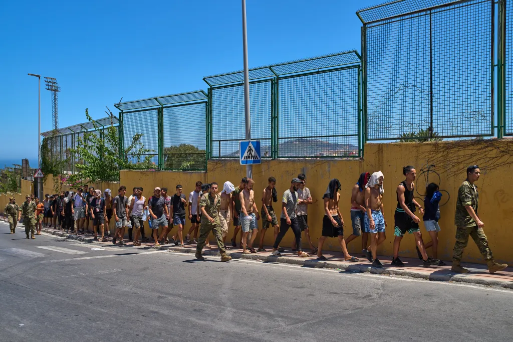 Migrants escorted by Spanish soldiers towards the Spanish-Moroccan border from the Spanish enclave of Ceuta.