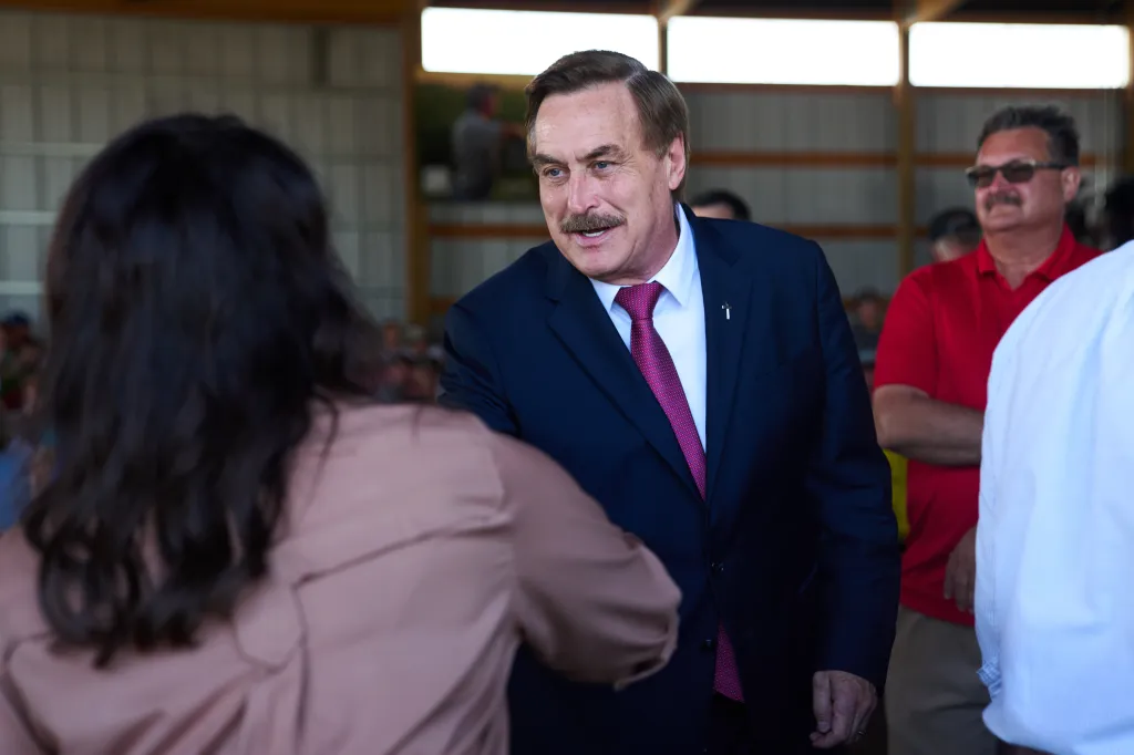 Mike Lindell shaking hands with Lisa Demuth at a candidate forum.