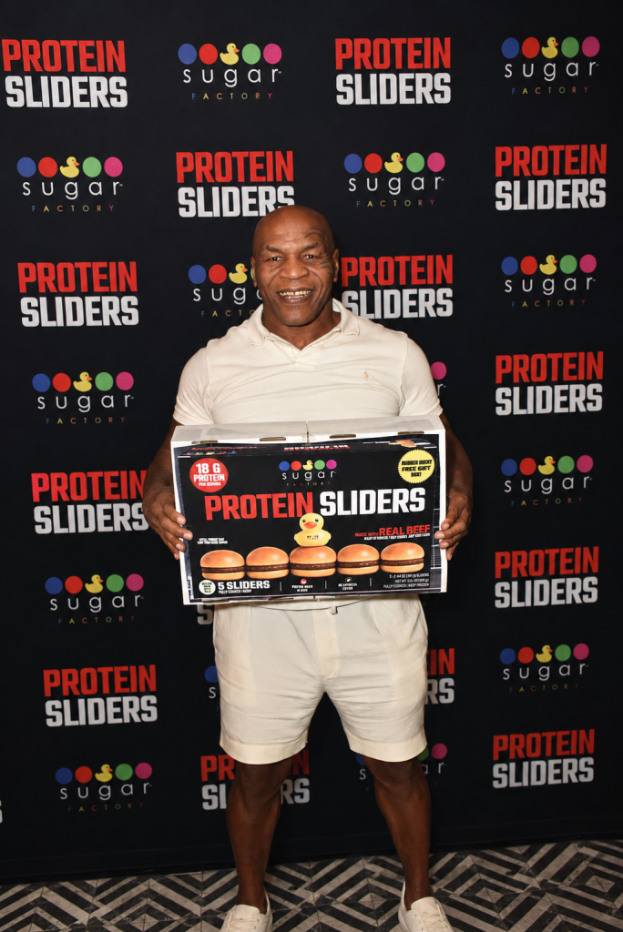 Mike Tyson holding a box of Sugar Factory Protein Sliders.