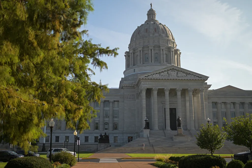 The Missouri State Capitol building with its dome and columns, framed by trees.