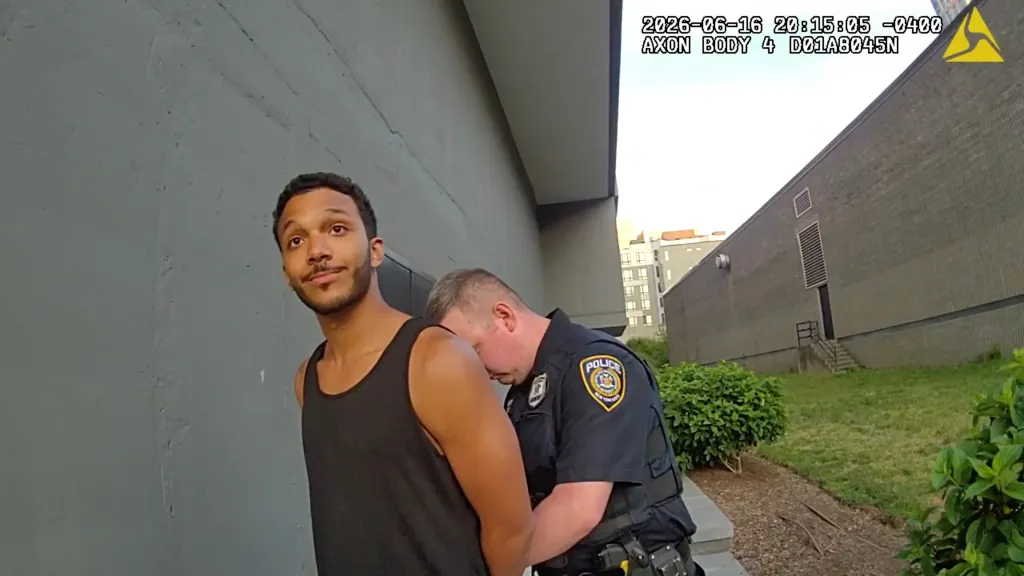 Gabriel Hostin being handcuffed by a police officer from a bodycam perspective.