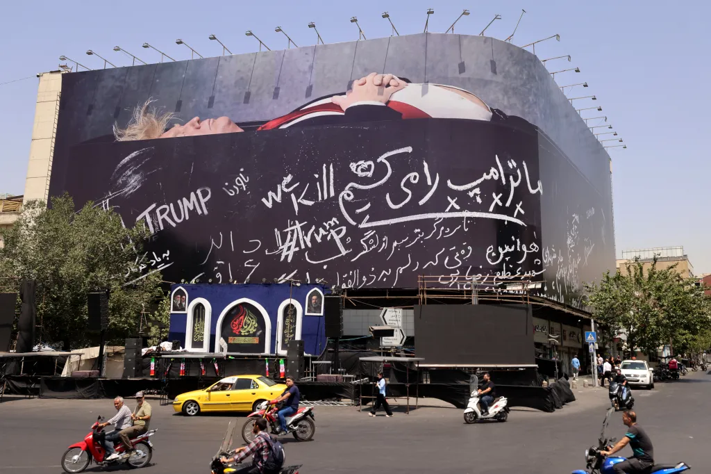 Motorists ride past a giant anti-US billboard featuring US President Donald Trump in a coffin with text in Persian reading