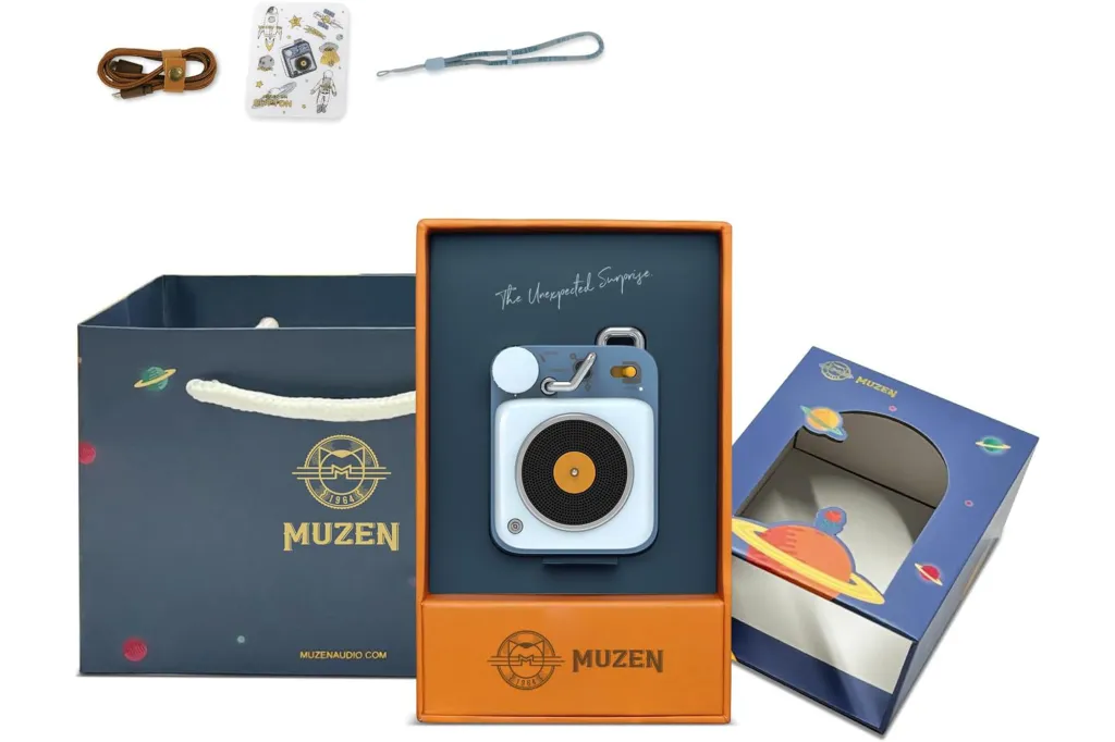 Muzen portable Bluetooth speaker in its packaging, with a charging cable, wrist strap, and space-themed stickers.
