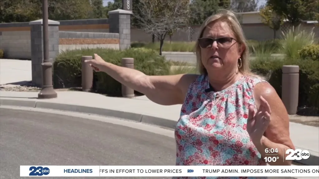 A woman in sunglasses and a floral top gestures while discussing the proposed Costco development in Bakersfield.