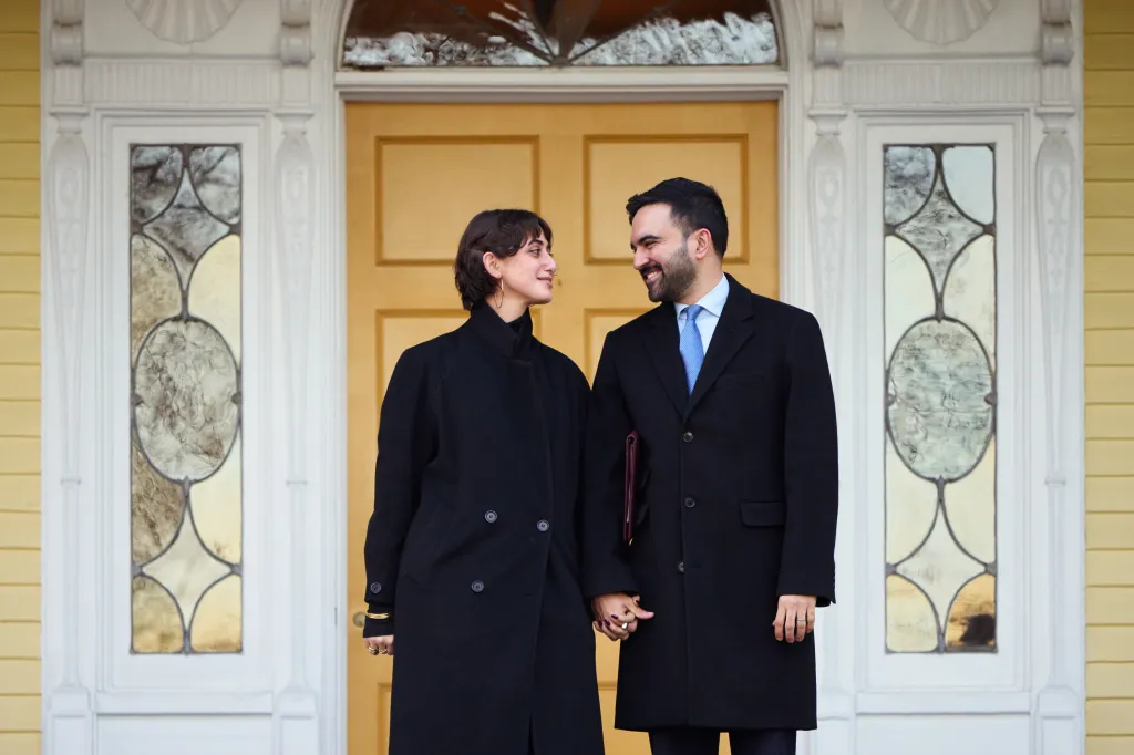 Mayor Zohran Mamdani and First Lady Rama Duwaji holding hands at Gracie Mansion.
