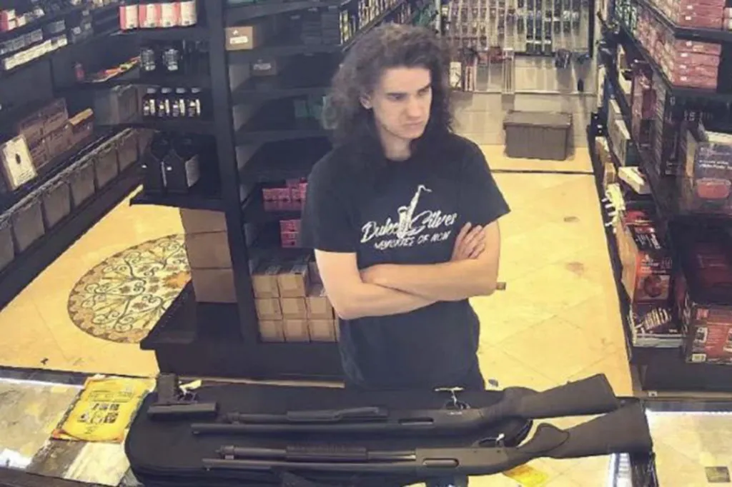 Nicholas Roske in a gun shop with two shotguns on the counter.