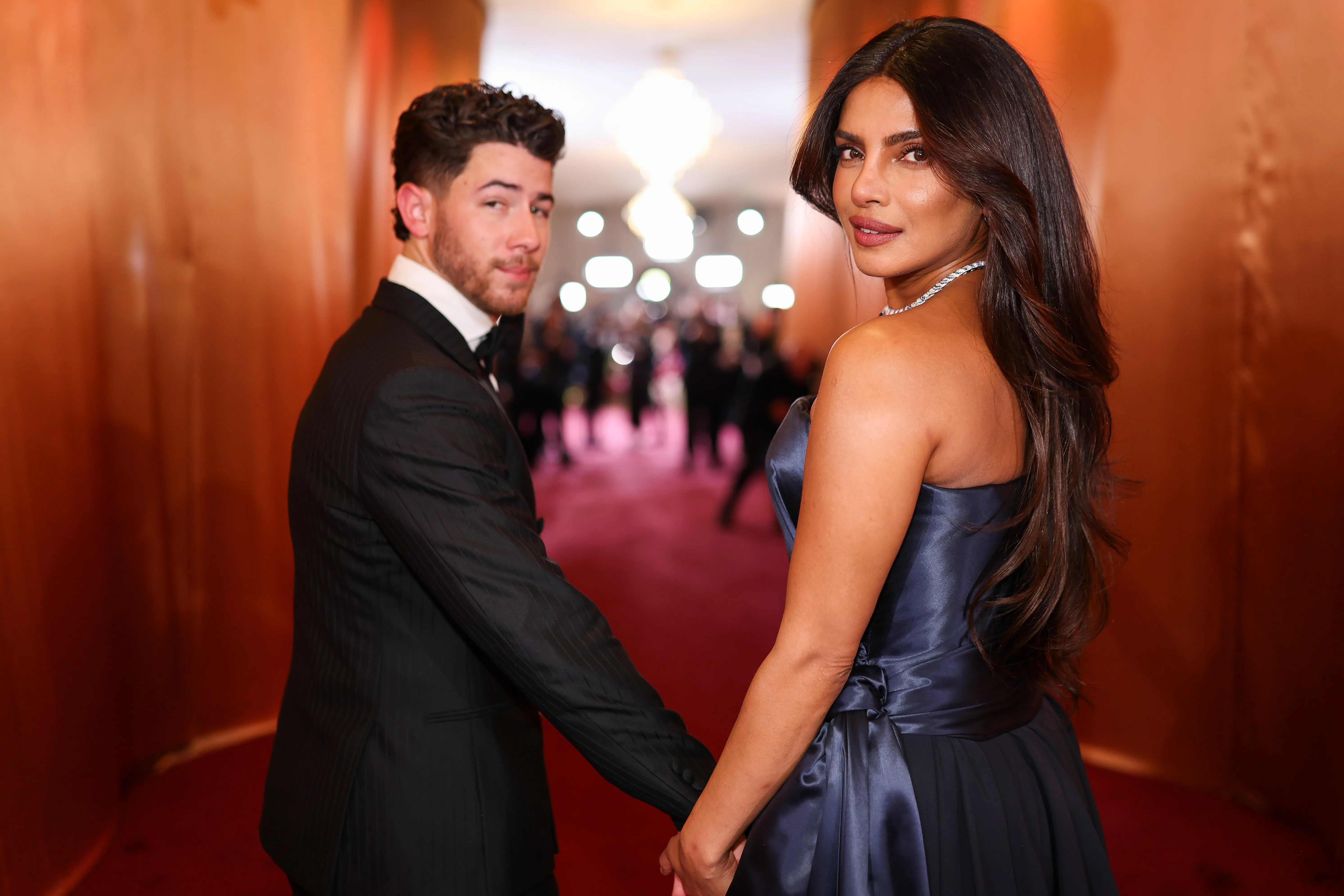 Nick Jonas and Priyanka Chopra holding hands on a red carpet.