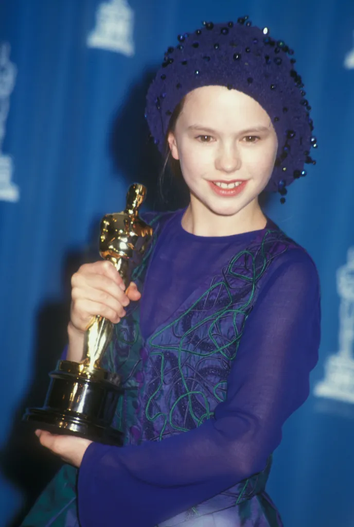 Anna Paquin holding an Oscar award.