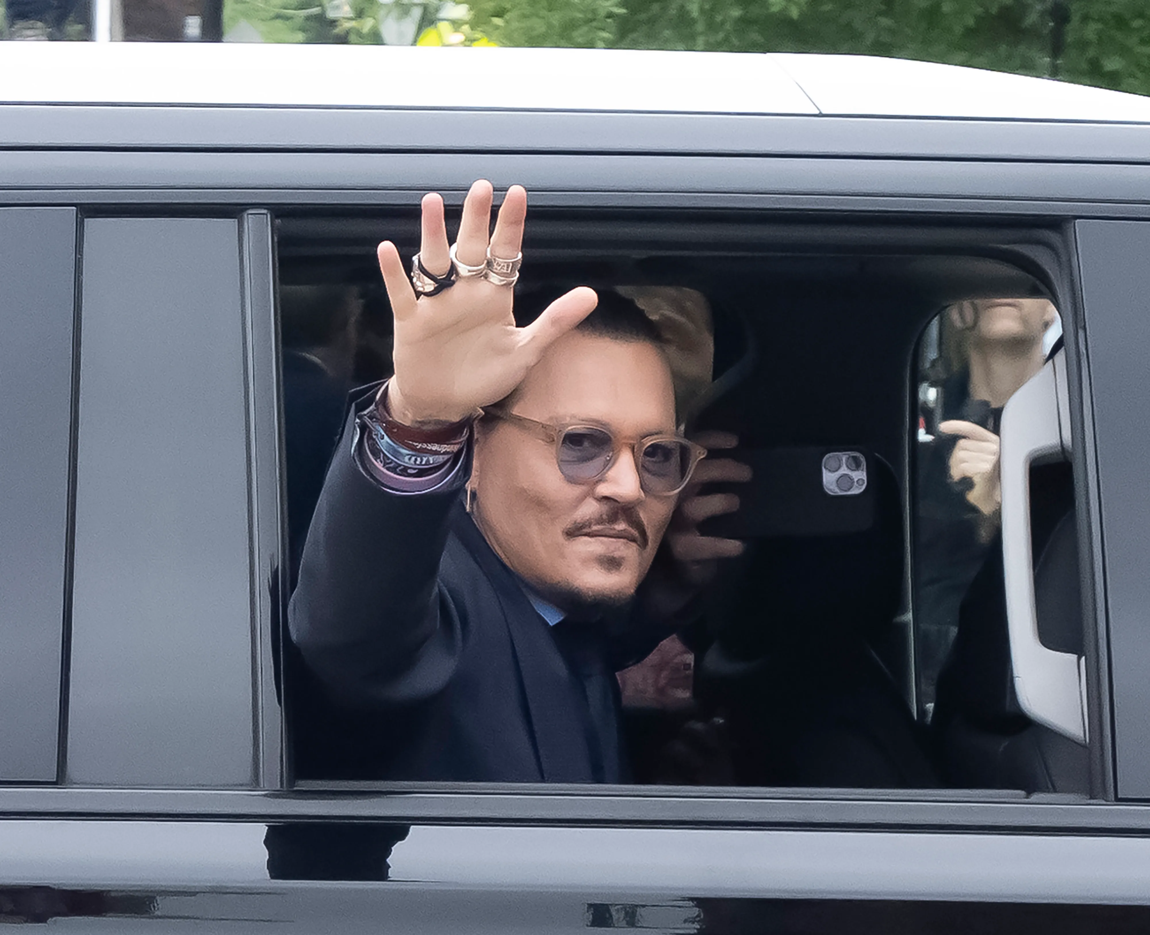 Johnny Depp waves from a car window.