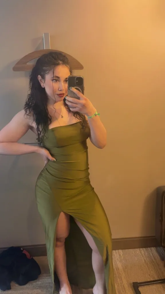 Ilana Schachter takes a mirror selfie while wearing an olive green dress.