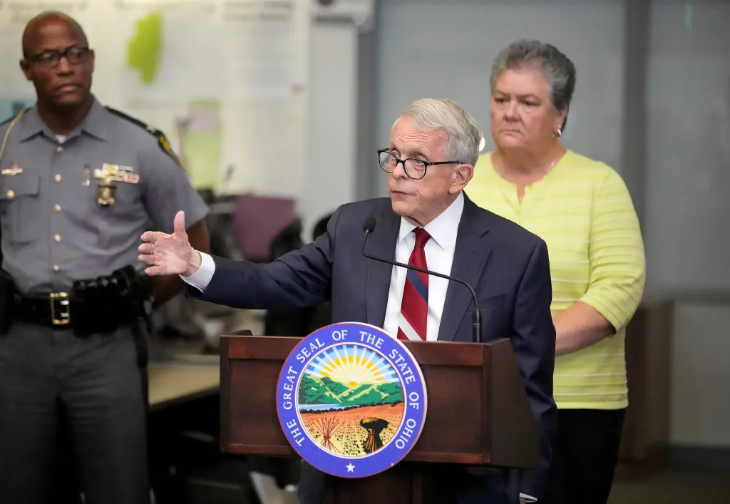 Ohio Governor Mike DeWine speaks at a press conference about severe weather, flanked by a police officer and another official.