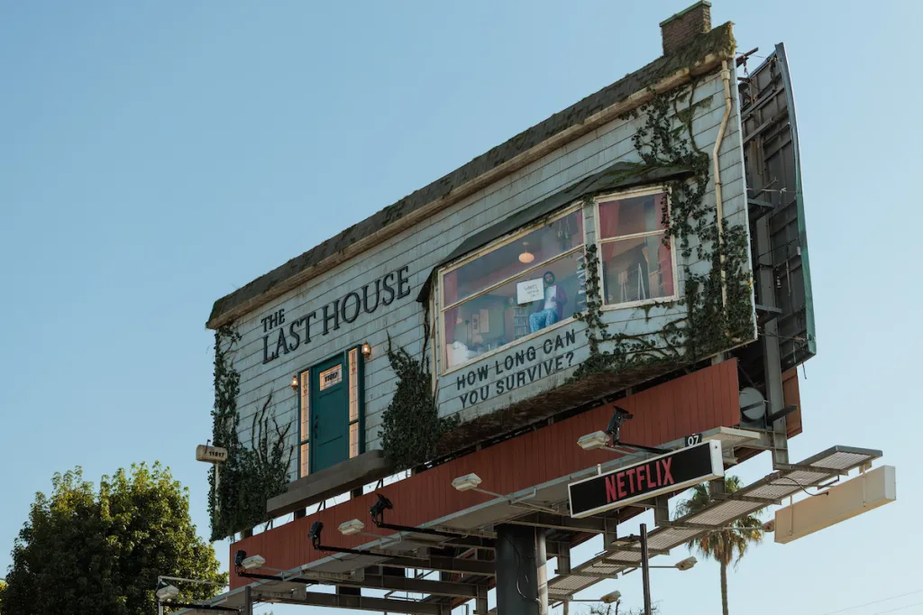 A man living in a furnished room built into a billboard advertising 