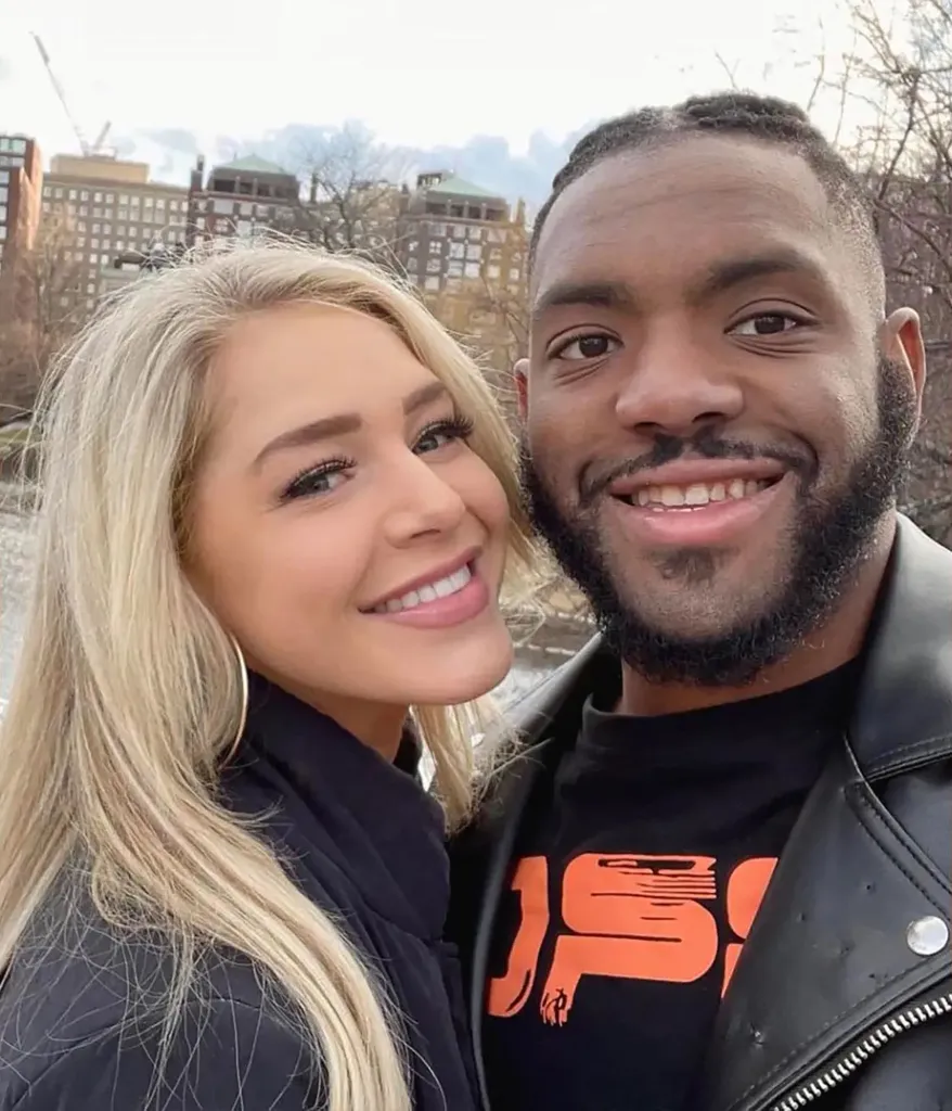 Courtney Clenney and Christian Obumseli smiling together outdoors.
