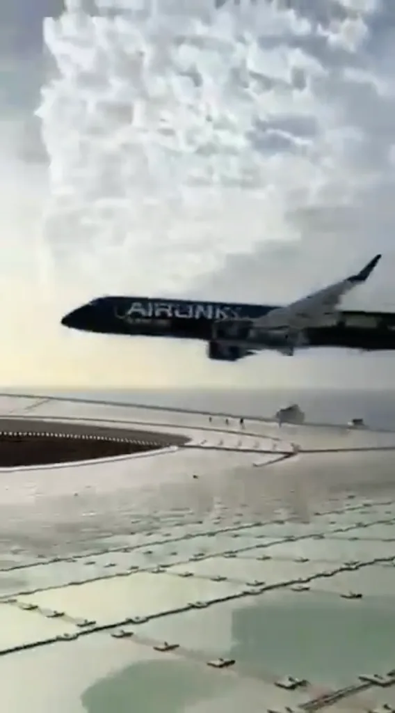 A black Airlink plane flying low over a football stadium in Cape Town.