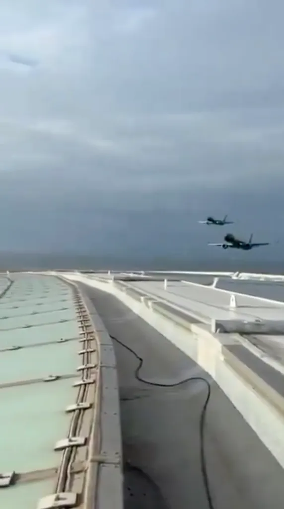 Two South African regional airline jets flying low over a football stadium in Cape Town.