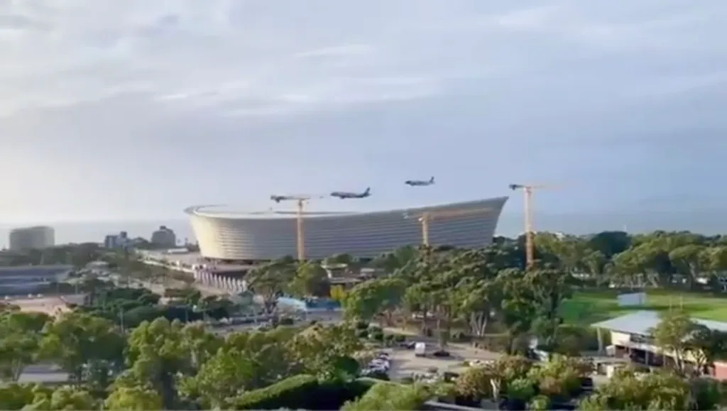 Two South African regional airline jets performing a low flyover of a football stadium in Cape Town.
