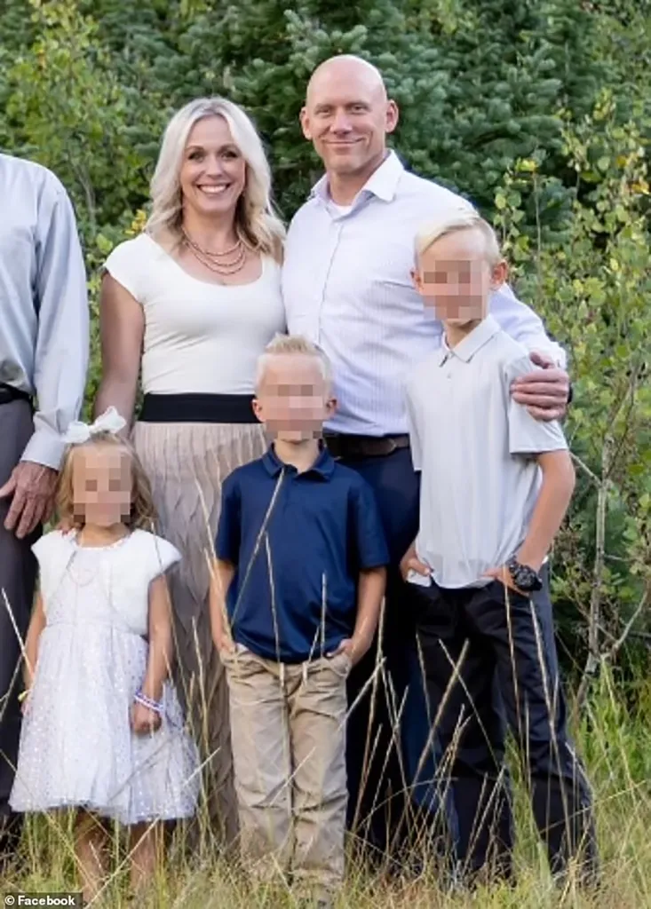 A family of five, with faces blurred, stands outdoors in tall grass with green bushes in the background.